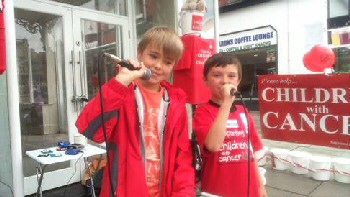Singing for charity in Southport are volunteers Oliver Bailey (10) from Leyland Road, Southport and (right) Dylan Bennett (8) from Maxton Road, Liverpool. 