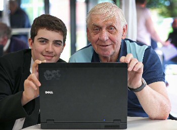 Photograph caption three: Stephen Moss, 13, helps Patrick Goodison get active online at Joseph Williams Mews.
